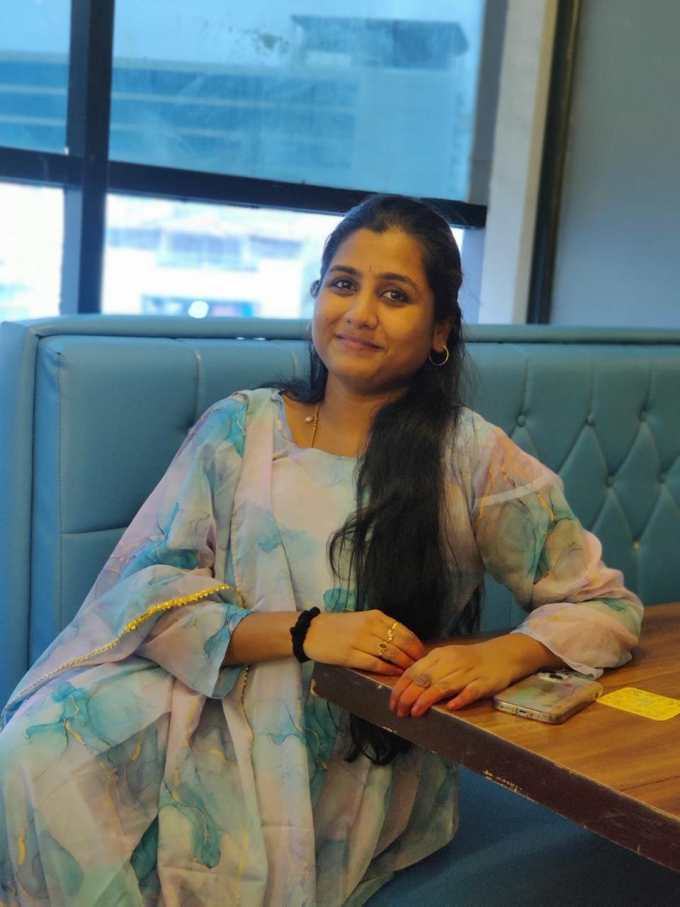 Dr. Pranathi seated at a café table, smiling