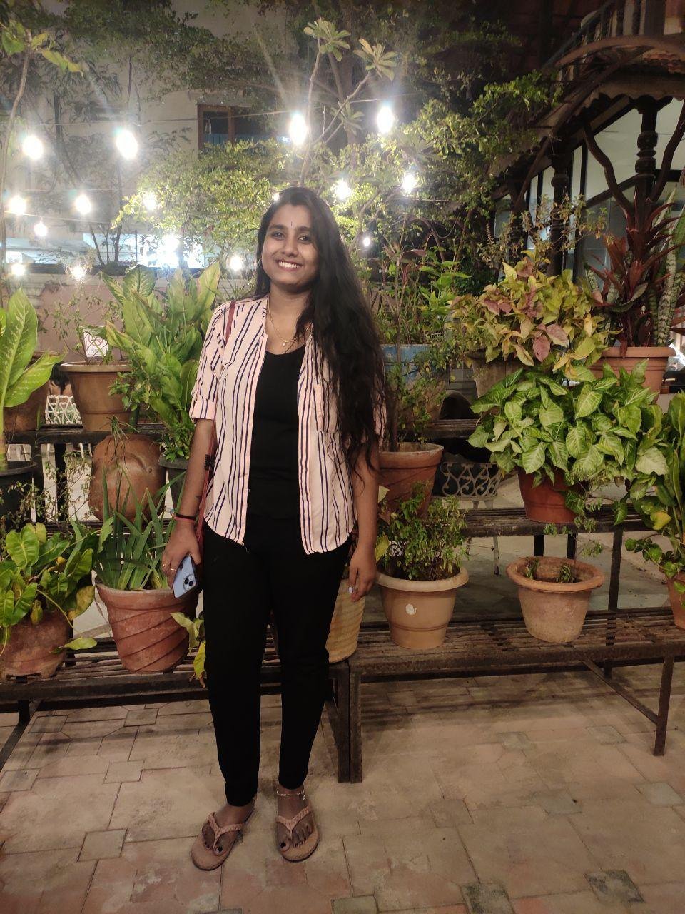 Dr. Pranathi smiling in a garden courtyard in the evening