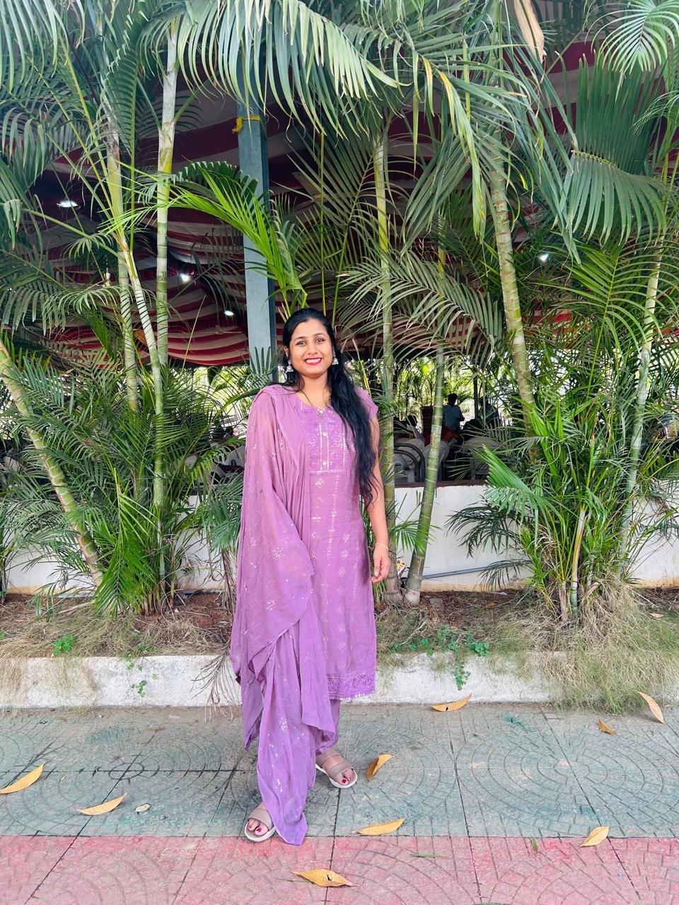 Dr. Pranathi outdoors among palm trees