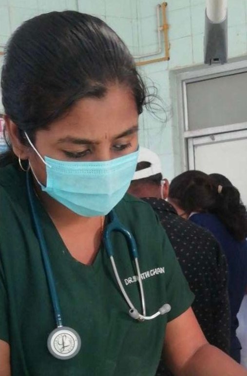 Dr. Pranathi in scrubs and a surgical mask, at work on a hospital ward
